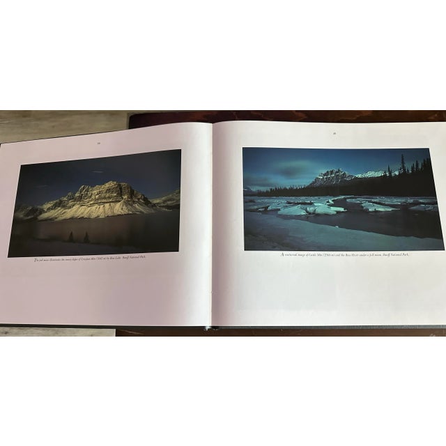 Beautiful large black hardcover book with gold lettering that contains photographs of the Canadian Rocky Mountains. A...