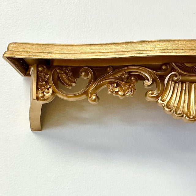 This is a Mid-Century Syroco Style Wall Bracket Shelf. It features a Neoclassical Hollywood Regency flare with a front...