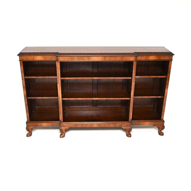 A superb antique walnut breakfront open bookcase. This was made in England, it dates from around the 1920’s period. It is...