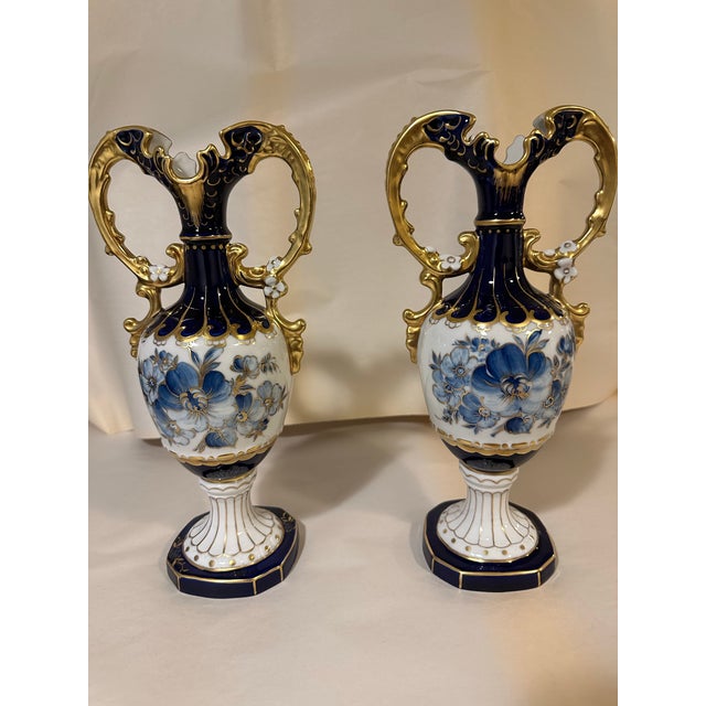 Beautiful pair of porcelain Royal Dux cobalt blue vases with blue flowers and gold double handles. Hand-painted and made...