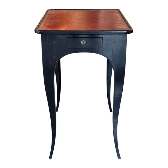 A 19th century ebonized side table, the rectangular top laid with red leather tooled in gilt at the borders and centered...