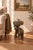 A sculptural vintage elephant side table or stool, hand-carved from a single solid block of tropical hardwood and likely...