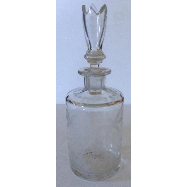 This delicate French decanter has etched palm trees and other flora around the piece as well as on the unusually shaped...