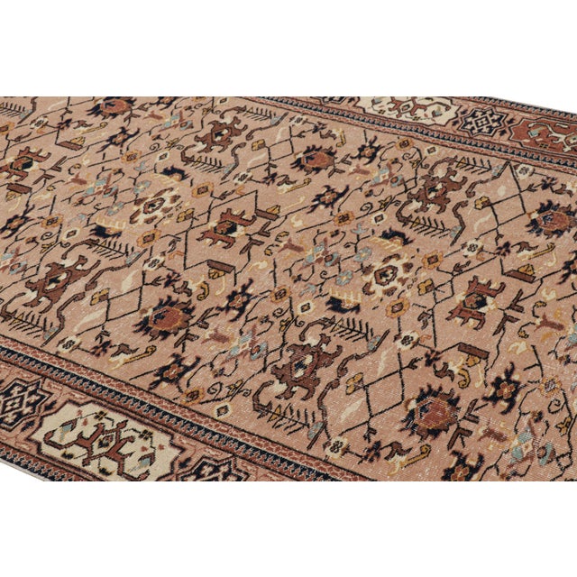 Hand-knotted in wool, this 5x8 vintage rug originating from Turkey, circa 1950-1960, is a very special piece, featuring a...