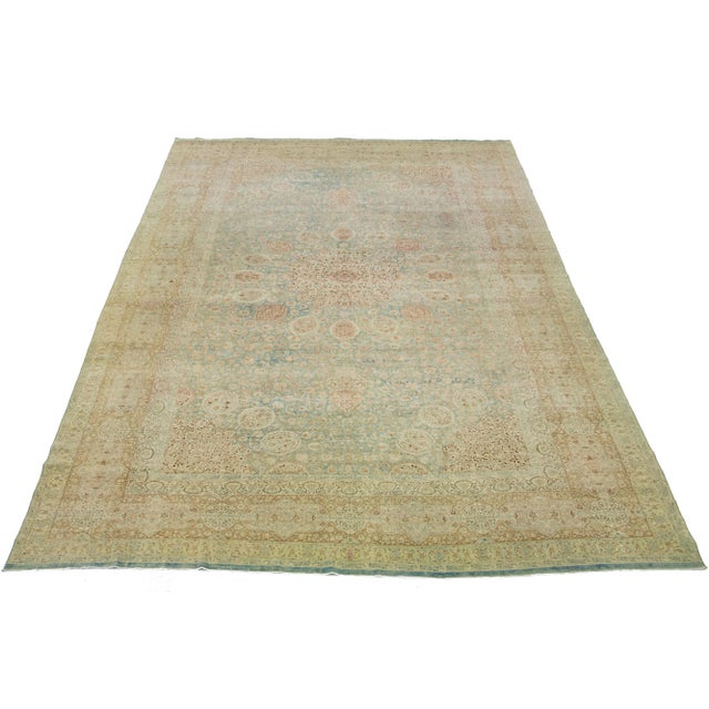 This exquisite, hand-knotted wool rug from Kerman boasts a charming antique finish. The rug's warm blue color field is...