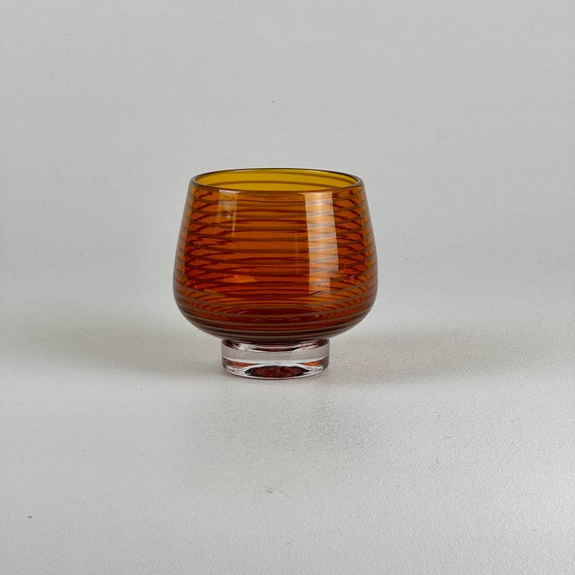 A stunning vintage hand blown small round art glass vase in amber color with a white swirling stripe. It is illegibly...