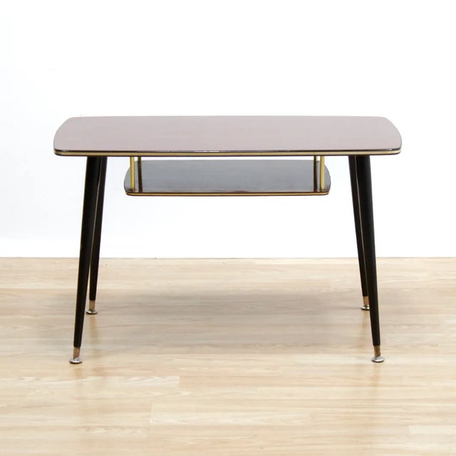 This mid-century atomic side table was designed and manufactured in England during the 1960s. With a fantastic mix of wood...