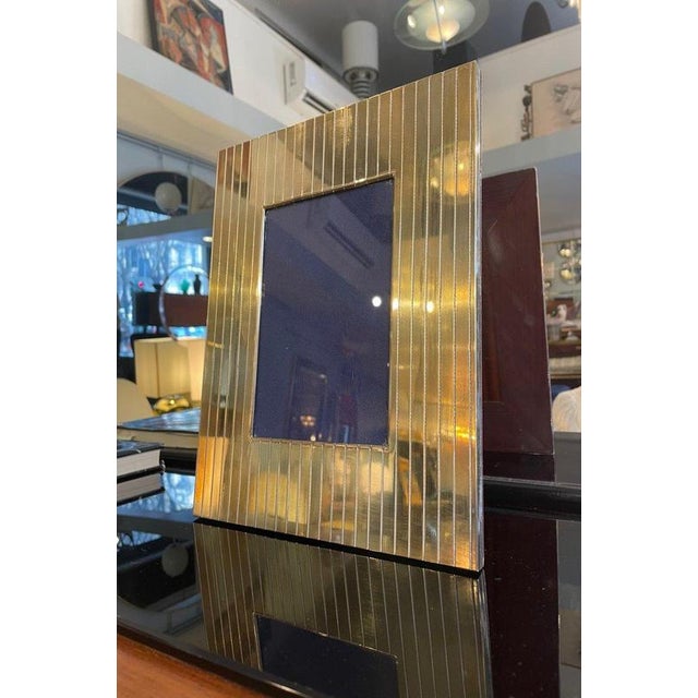 Photo frame with a fluted brass front and blue velvet backing. A refined and elegant piece that adds a chic, timeless...