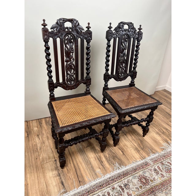 A handsome pair of late 19th-century French hunting chairs crafted from solid walnut and richly carved with foliate and...