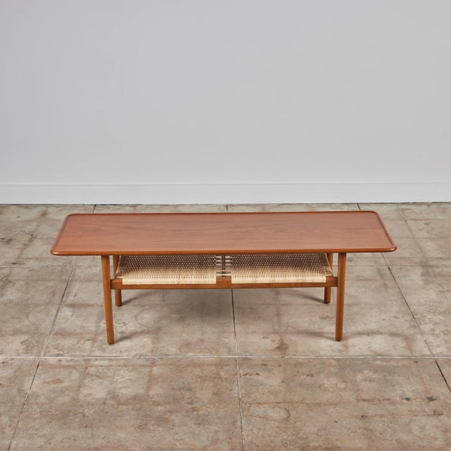 Coffee table designed by Hans Wegner for Andreas Tuck in 1955, produced in Denmark. A broad tabletop with a rounded and...