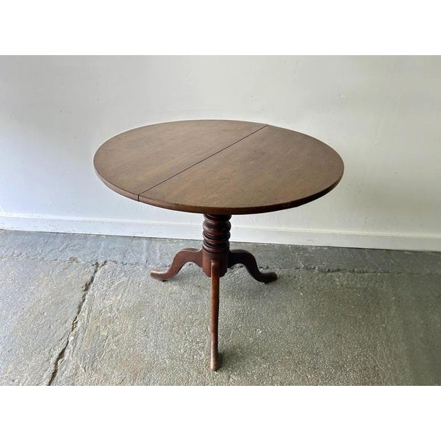 Antique English Georgian oak tilt-top tripod table, circa 1780–1820. Featuring a circular two-board top, turned pedestal,...