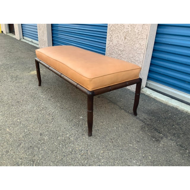 Mid century modern walnut bench with leather upholstery. The bench is done is the manner of Robsjohn Gibbings . This style...