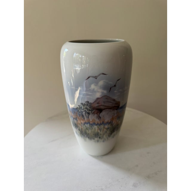 A stunning example of Royal Copenhagen’s celebrated naturalistic porcelain painting, this elegant vase wraps a fully...