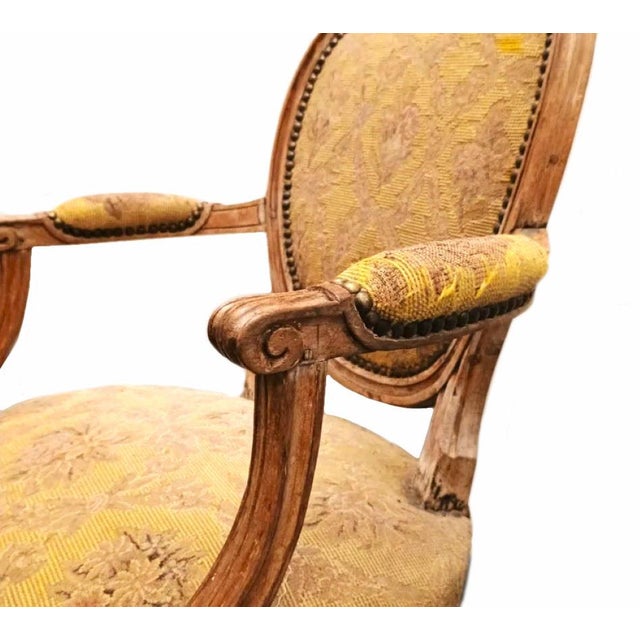 Stripped beech armchair with medallion back, molding and carved rosettes, resting on fluted legs, Louis xvi period