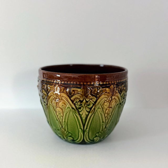This large majolica jardinière by Weller showcases classic Art Nouveau style with a geometric and floral design in relief...