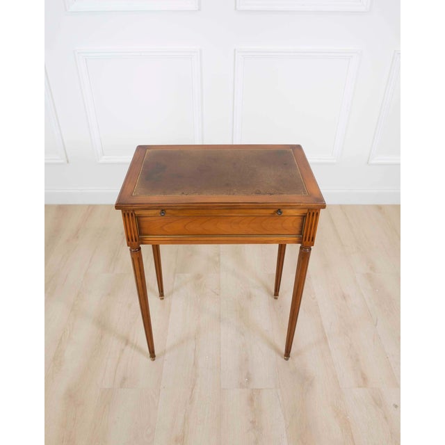 Made in France in the twentieth century, this small Louis XVI style side table is constructed in cherrywood, with a pull-...
