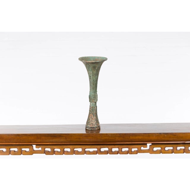 A vintage lost wax cast bronze flute shaped ceremonial vessel from the mid 20th century, with verde patina. Created with...