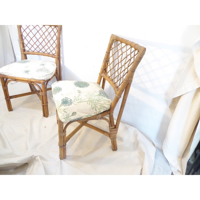 This pair of bamboo chairs have faded, distressed seat cushions which can be re-covered.