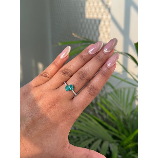 This Toi et Moi bypass ring is features a 1 carat two oval-shaped emeralds set in 14K white gold. Each emerald measuring...