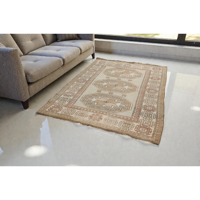 This is a vintage Turkish Oushak rug from the Mid 20th Century. The piece was hand-knotted.