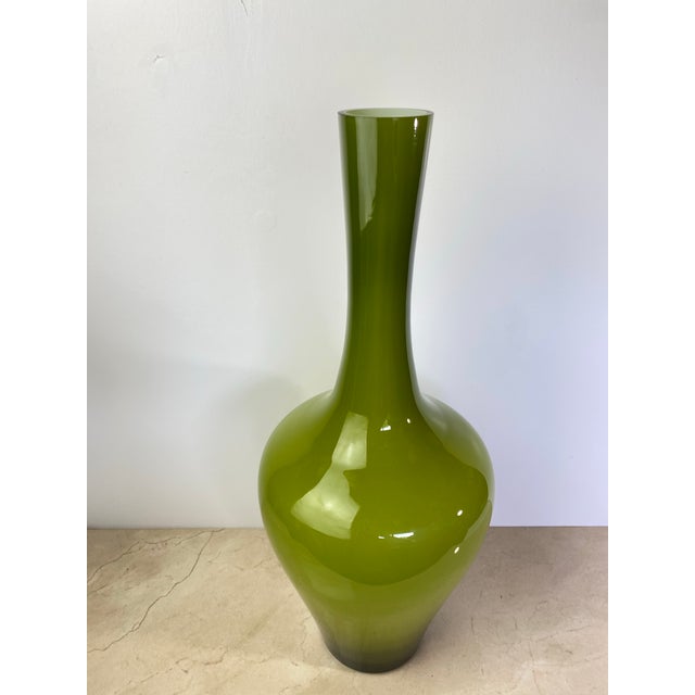 A striking mid-century bottle-form vase in richly saturated olive green cased glass — hand-blown with an outer olive layer...