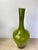 A striking mid-century bottle-form vase in richly saturated olive green cased glass — hand-blown with an outer olive layer...