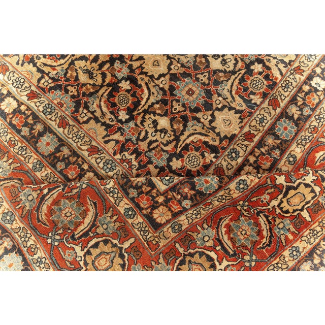 An early 20th century Persian Kirman (Kerman) antique carpet, the black field with a dense herati pattern in red, golden...