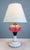 A beautiful old converted oil lamp with swirled cranberry glass body, deco style milk glass base and cut and pierced...
