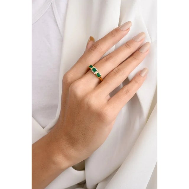 This is part of Chairish’s Fine Jewelry assortment. Modern Emerald Diamond Halo Three Stone Ring in 18K Gold featuring...