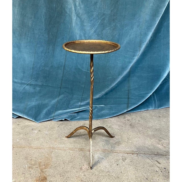 This unique small side table from Spain stands out with its round top enclosed in a rolled rim, mounted on an ornamental...