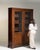 This piece presents as a bookcase, distinguished by dark mahogany, glass door, open shelving. It was made in France during...