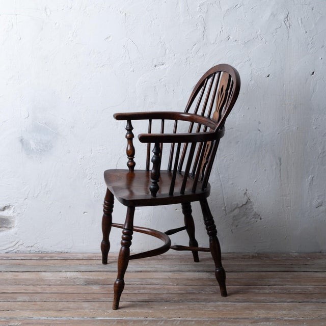 An English elm and ash windsor chair with crinoline stretcher, 19th century. 22 ½ inches wide by 21 inches deep by 36 ½...