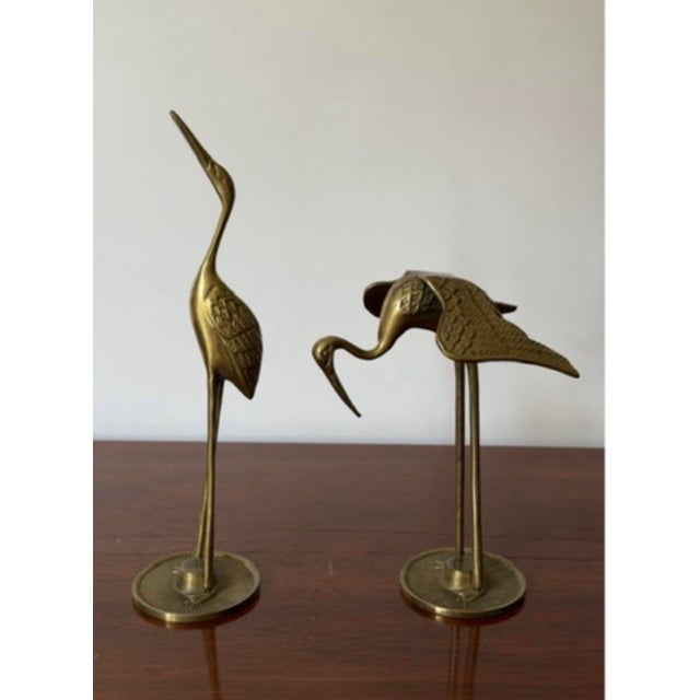 Pair of vintage solid brass crane/heron sculptures, circa 1970s. The set features two complementary poses: one tall...