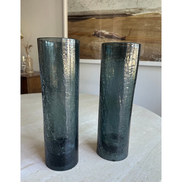 A striking pair of vintage tall cylinder hurricane candle holders in smoky slate blue crackle glass. The all-over crackle...