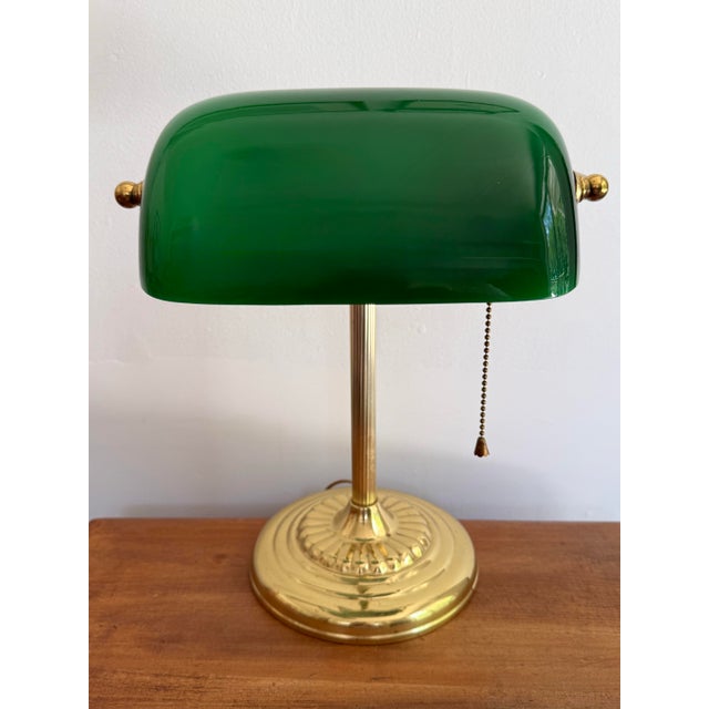 Beautiful brass banker's desk lamp with Emeraldite green glass shade and drawstring pull. A classic and traditional touch....