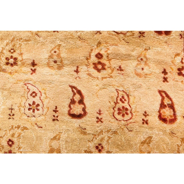 An early 20th century Indian Amritsar carpet, the cream field with simple botehs staggered allover in shades of brown and...