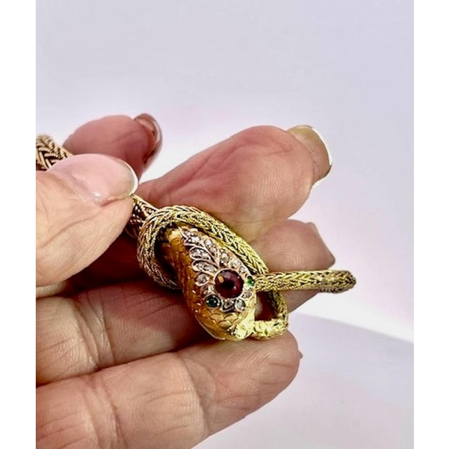 This captivating serpent bracelet is crafted in rich yellow gold, featuring a finely woven herringbone-pattern chain that...
