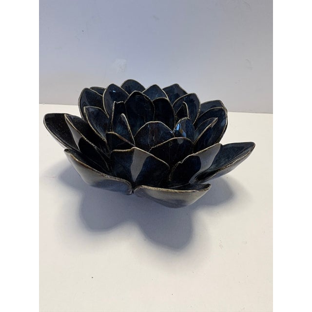 A sculptural handmade ceramic bowl formed as a layered lotus blossom, finished in a rich midnight-blue glaze with hand-...
