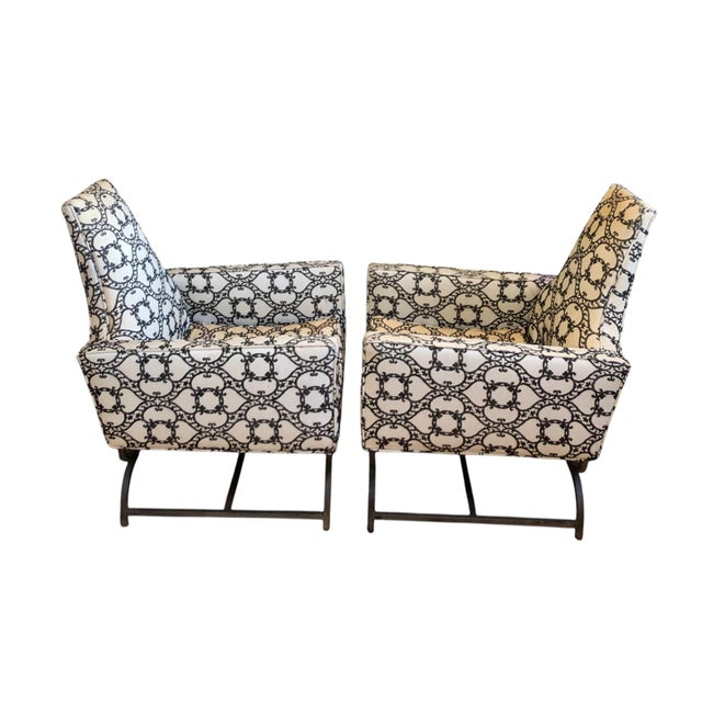 Vintage Midcentury chairs each featuring a high-back, wide arms and a decorative upholstery. The chairs are supported by...