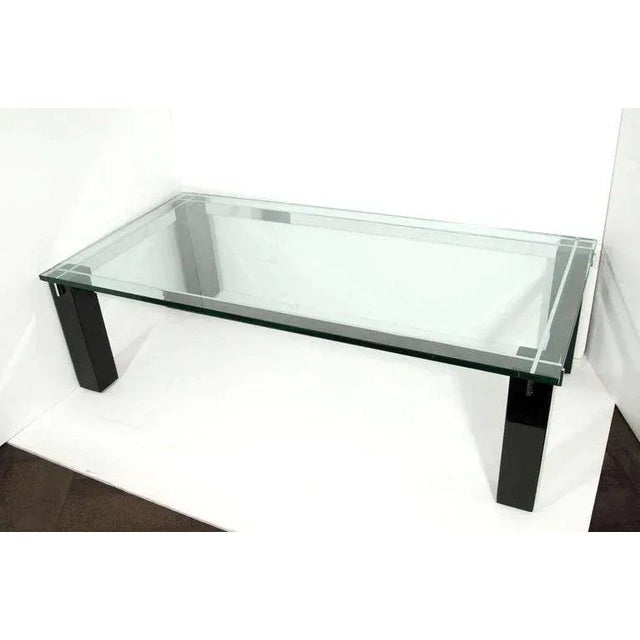 Large Mid-Century Modern coffee table with architectural design. Features heavy glass top over ebonized mahogany wood...