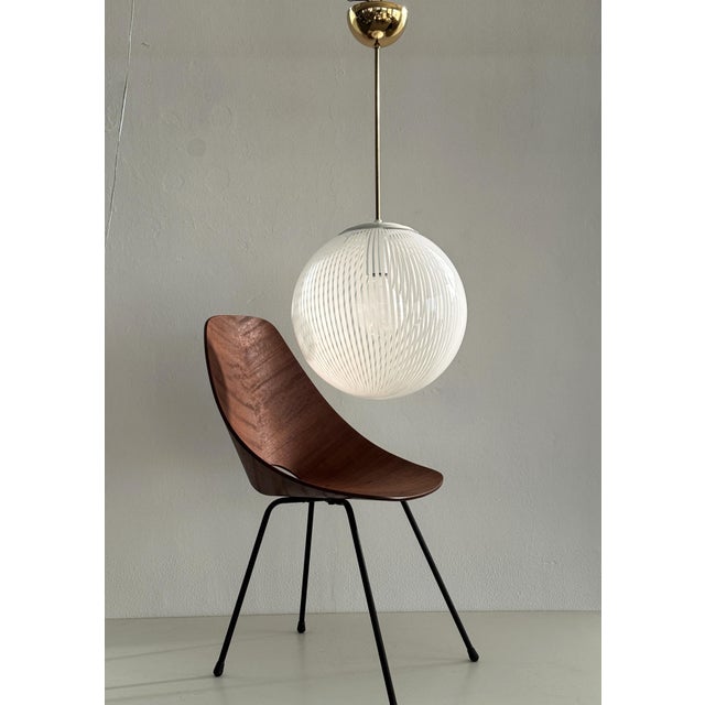 Italian Chandelier from Venini manufacturing with large glass sphere with shiny white stripes. Leaves beautiful shadows on...