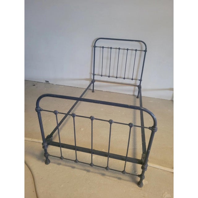 Antique style wrought iron bed frame, composed of four pieces. The two side crosspieces have an interlocking assembly...