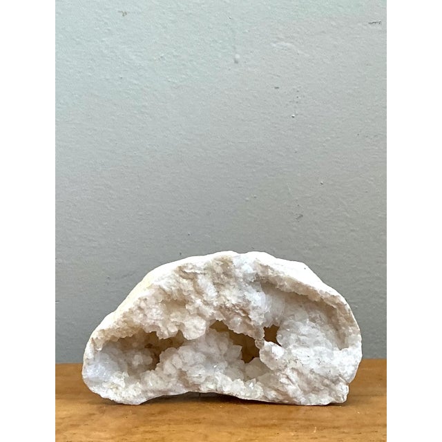 Evolving through natural geological crystallization over millennia, this authentic white quartz geode specimen reveals an...
