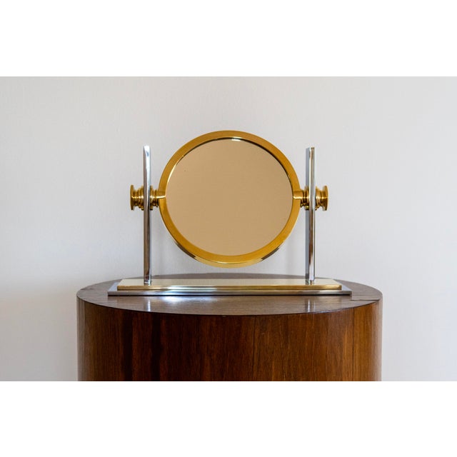 A sophisticated tabletop vanity mirror by Karl Springer, executed in polished nickel and brass with the refined, luxurious...