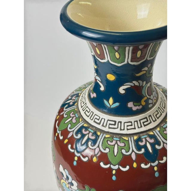 This Art Nouveau enamelled faience vase, produced in France around 1910 and likely originating from the Longwy region, is...