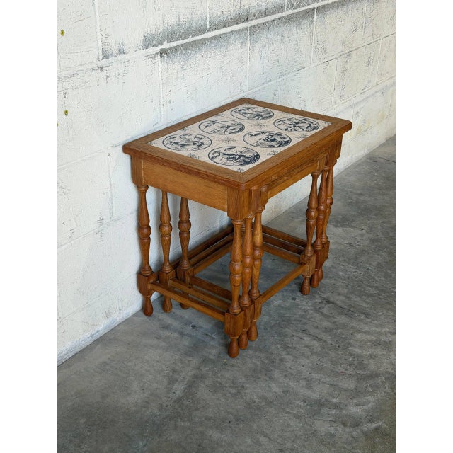 This set of three nesting tables features a classic silhouette with intricately turned legs. The inlaid ceramic tile...