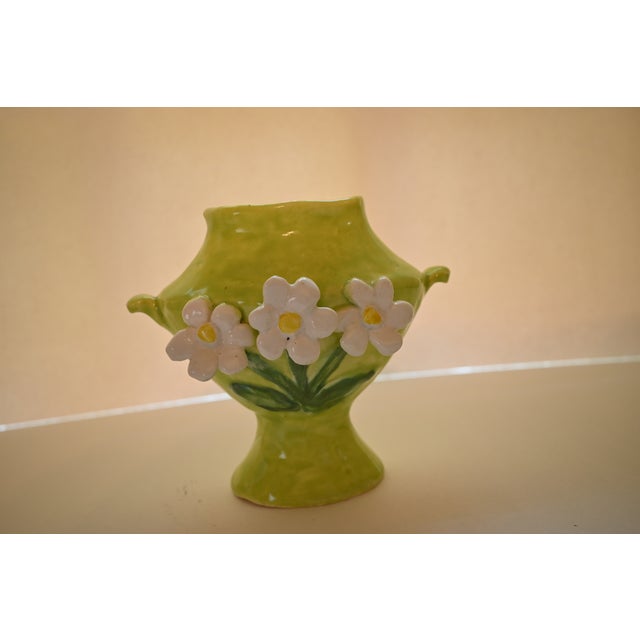 This Dana Gibson spill vase features three applied daisies on a apple green form with small handles. Whimsical, it is...