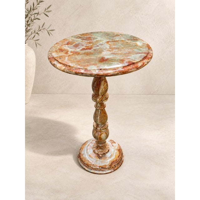 Elevate your interior with this exquisite natural onyx pedestal table, handcrafted from beautifully veined stone in a...