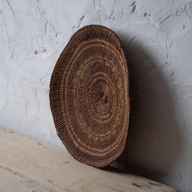 A Karuk winnowing tray basket, circa 1900. 11 ¾ by 11 ¼ inches; 2 inches deep
