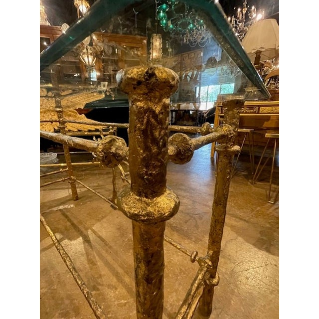 The Italian Gilded Iron Table after Diego Giocometti is a luxurious and elegant piece of furniture designed to add a touch...